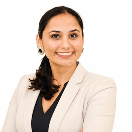 Raj Kiran Kaur, a professional headshot showing a smiling woman in business attire.
